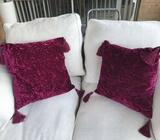 Two burgundy crushed velvet tassel cushions