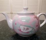 2 teapots, one rich green, the other pink with a design